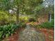 Scenic stone pathway amidst lush greenery, mature trees, and manicured landscaping at 1073 Crooked Oak Dr., Pawleys Island, SC 29585
