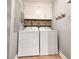 Functional laundry room with washer, dryer, overhead cabinets, and convenient storage baskets at 1073 Crooked Oak Dr., Pawleys Island, SC 29585