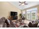 Comfortable living room with leather sofas, entertainment center, ceiling fan, and a view to the backyard at 1149 6Th Ave. S, North Myrtle Beach, SC 29582