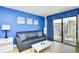 Comfortable living room with blue sofa and balcony access provides great views and ample natural light at 1207 S Ocean Blvd. # 51012, Myrtle Beach, SC 29577