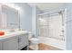 Bathroom with light blue walls, a shower and tub combo, and a gray vanity at 1208 River Oaks Dr. # 24-B, Myrtle Beach, SC 29579