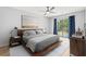 Bedroom features a wooden bed frame, stylish linens, modern decor, and access to a private balcony at 1208 River Oaks Dr. # 24-B, Myrtle Beach, SC 29579