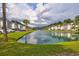A pond within a community, surrounded by palm trees and townhomes at 1208 River Oaks Dr. # 24-B, Myrtle Beach, SC 29579