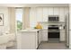 Bright kitchen with white cabinets, stainless steel appliances, an island, and a large window at 1218 Willow Oaks Way, Conway, SC 29526