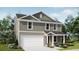 Charming two-story home with a light green exterior, white trim, attached garage, and well-manicured front yard at 1222 Willow Oaks Way, Conway, SC 29526