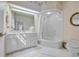 A tiled bathroom boasting a tub and shower combination, white vanity and decorative wallpaper at 1259 Oatland Lake Rd., Pawleys Island, SC 29585