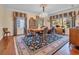 A formal dining room boasts a chandelier, hardwood floors, and great views of the outdoors at 1259 Oatland Lake Rd., Pawleys Island, SC 29585
