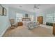 A comfortable main bedroom is painted with light colors, large windows and a rocking chair at 1259 Oatland Lake Rd., Pawleys Island, SC 29585
