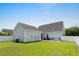Large backyard with lush lawn, patio seating, and view of the home's exterior at 136 Southbury Dr., Myrtle Beach, SC 29588