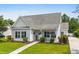 Charming single story home with manicured lawn, walkway, gray siding, black shutters, and a cozy front porch at 136 Southbury Dr., Myrtle Beach, SC 29588