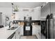 Well-lit kitchen with white cabinets, stainless steel appliances, black backsplash and composite countertops at 136 Southbury Dr., Myrtle Beach, SC 29588