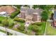 Aerial view of a landscaped backyard with a wooden deck, brick chimney, stone bench, and well-maintained lawn at 1468 Fox Hollow Way, North Myrtle Beach, SC 29582