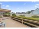 Wide angle of a spacious wooden deck featuring a charming pergola and lush, manicured landscaping for outdoor enjoyment at 1468 Fox Hollow Way, North Myrtle Beach, SC 29582