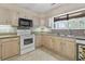 Close-up of the kitchen area with wooden cabinets, backsplash, and stainless steel appliances at 1468 Fox Hollow Way, North Myrtle Beach, SC 29582