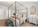 Spacious main bedroom with a canopy bed, side tables, and a well-lit view to an ensuite bathroom at 1523 Wood Stork Dr., Conway, SC 29526
