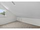 Cozy carpeted attic space featuring a window and storage door at 154 Cedar Point Ave., Murrells Inlet, SC 29576