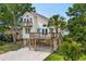 Charming beach home featuring a spacious deck, complemented by a well-maintained yard and a convenient ground-level carport at 154 Cedar Point Ave., Murrells Inlet, SC 29576