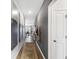 Stylish hallway with hardwood floors and neutral walls, with decorative art, and doorway views to the living spaces at 154 Waterloo Sunset Dr., Longs, SC 29568