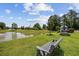 Scenic view of a pond featuring a fountain, landscaping, and seating with a bench for relaxation at 141 Lazy Willow Ln. # 103, Myrtle Beach, SC 29577