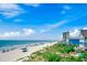 Oceanfront beach with white sand, blue ocean, sunny skies, and homes on the shoreline at 1615 S Ocean Blvd. # 4, Surfside Beach, SC 29575