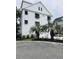 Charming white three-story home with palm trees and a three-car garage at 17 Carson Creek Dr., Murrells Inlet, SC 29576