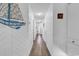 Well-lit hallway featuring wood-look flooring, fresh white paint, and nautical decor at 1870 Auburn Dr. # 22A, Surfside Beach, SC 29575