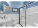 Stylish bathroom features a pedestal sink, modern fixtures, wainscoting, and a glass-enclosed shower at 213 South Myrtle Dr., Surfside Beach, SC 29575