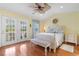 Bright bedroom features wood floors, a ceiling fan, and private access to a balcony through French doors at 213 South Myrtle Dr., Surfside Beach, SC 29575