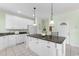 Bright kitchen featuring a center island with seating, white cabinets, and granite countertops perfect for meal preparation at 213 South Myrtle Dr., Surfside Beach, SC 29575