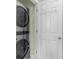 Convenient laundry area with stacked washer and dryer and a white door at 213 South Myrtle Dr., Surfside Beach, SC 29575