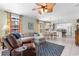 Open living room boasts tile floors, a ceiling fan, and a seamless transition to the dining area and kitchen at 213 South Myrtle Dr., Surfside Beach, SC 29575