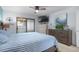 Comfortable main bedroom with ceiling fan, dresser, TV, and sliding door to screened porch at 223 Maison Dr. # B-8, Myrtle Beach, SC 29572