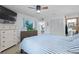 Comfortable main bedroom with ceiling fan, dresser, TV, and sliding door to screened porch at 223 Maison Dr. # B-8, Myrtle Beach, SC 29572