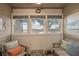 Charming screened porch with ceiling fan, windows, and comfortable chairs with pillows to enjoy the outdoors at 223 Maison Dr. # B-8, Myrtle Beach, SC 29572