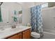 Bright bathroom with a vanity, white sink, and shower with a patterned shower curtain at 229 Coral Beach Circle, Surfside Beach, SC 29575