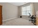 Neutral bedroom with a large window, a desk and rolling chair, and neutral carpeting at 229 Coral Beach Circle, Surfside Beach, SC 29575