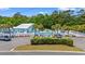 A gorgeous view of the community pool surrounded by lush landscaping and mature palm trees at 229 Coral Beach Circle, Surfside Beach, SC 29575
