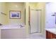 Bright bathroom featuring a soaking tub, glass-enclosed shower, and neutral-toned walls at 2499 Burning Tree Ln., Little River, SC 29566