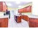 Well-lit kitchen with tile floor, central island, and wooden cabinetry at 2499 Burning Tree Ln., Little River, SC 29566