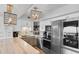 Modern kitchen features stainless steel appliances, white cabinets, marble countertops, and decorative pendant lighting fixtures at 2609 South Ocean Blvd. # 702, North Myrtle Beach, SC 29582