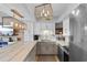 Kitchen with stainless appliances, white cabinets, marble countertops, and decorative light fixtures with access to living room at 2609 South Ocean Blvd. # 702, North Myrtle Beach, SC 29582