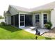 Backyard featuring a screened-in patio, a bear statue, and a lush lawn at 266 Tall Palms Way, Little River, SC 29566