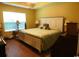 Comfortable bedroom featuring hardwood floors, soft lighting, and a large window at 266 Tall Palms Way, Little River, SC 29566