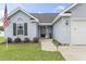 Inviting front entrance showcasing a well-maintained lawn, charming plants and a glass front door at 282 Foxpath Loop, Myrtle Beach, SC 29588