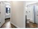 Hallway view showcasing access to a bedroom with natural light and a bathroom with a shower and toilet at 282 Foxpath Loop, Myrtle Beach, SC 29588