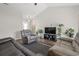 Bright living room with leather seating, wood floors, tv, plants, and lots of natural light at 282 Foxpath Loop, Myrtle Beach, SC 29588