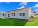 Spacious backyard featuring lush green grass, a small patio, and light gray siding at 3027 Deerberry Place, Longs, SC 29568