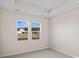 Bedroom featuring tray ceiling, neutral carpet, and two windows showcasing a pond view at 3027 Deerberry Place, Longs, SC 29568