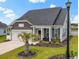Charming home featuring a well-manicured lawn, stone accents, and a welcoming covered front porch at 305 Portofino Dr., Myrtle Beach, SC 29579