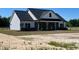 Inviting two-story home with white siding, a black roof, and a charming front porch perfect for relaxing at 3200 Fowler School Rd., Loris, SC 29569